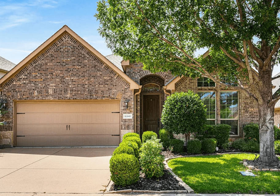 Beautiful suburban house with stone facade and lush landscaping.
