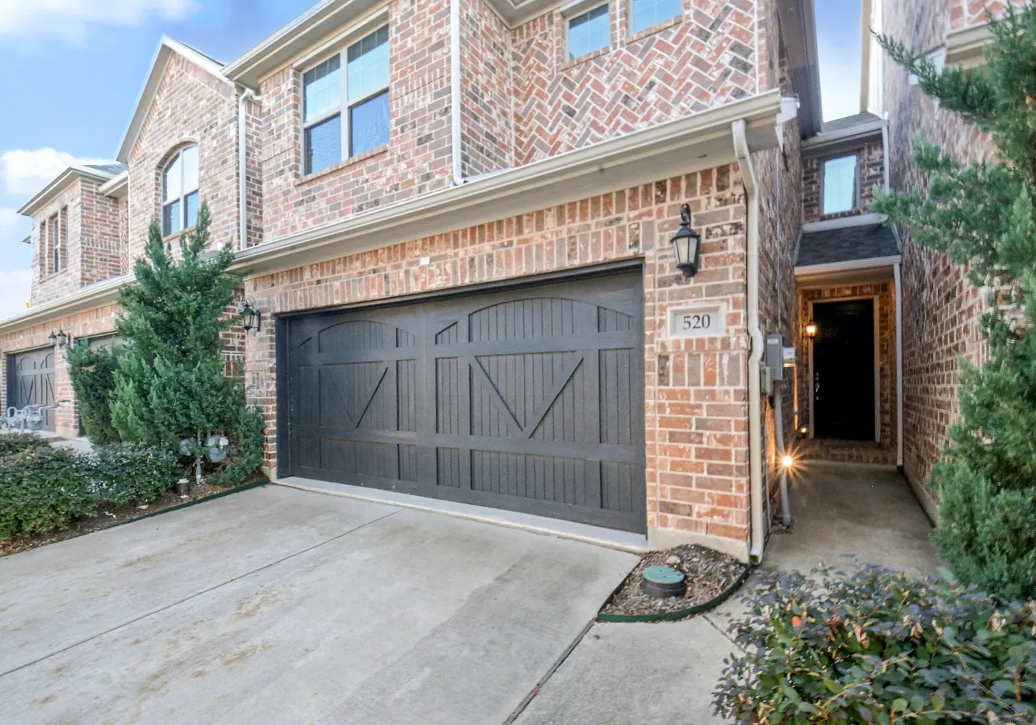 Brick townhouse with dark wooden garage door
